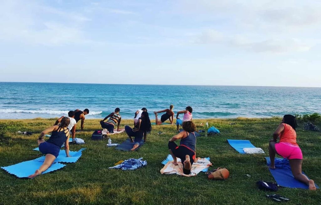 aurore Yoga cours de yoga extérieur en groupe face à la mer